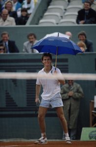 Andre Agassi of the United States wearing his jean style shorts holds an umbrella open in jest on court during a Men's Singles match against Massimiliano Narducci during the French Open Tennis Championship on 25th May 1988 at the Stade Roland Garros Stadium in Paris, France.(Photo by Bob Martin/Getty Images)